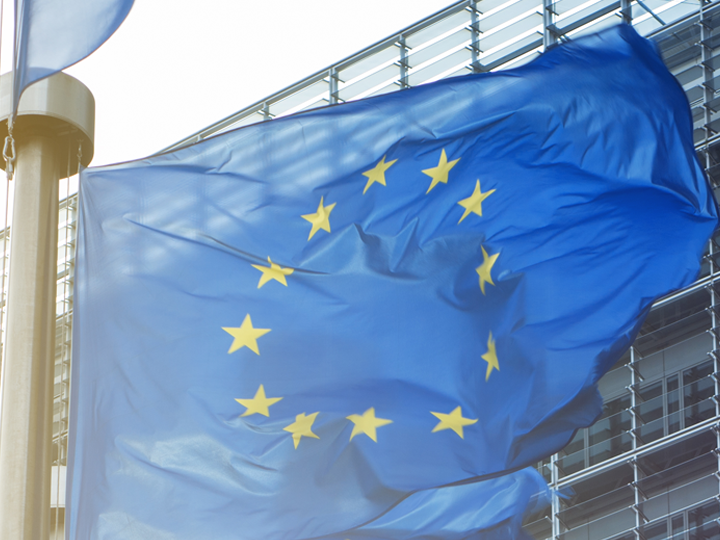 European Union flag against corporate building in the background