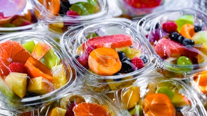 Plastic boxes with pre-packaged fruit salads, put up for sale in a commercial refrigerator