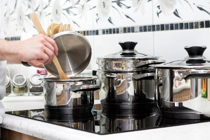 Man prepares dinner on modern induction cooker