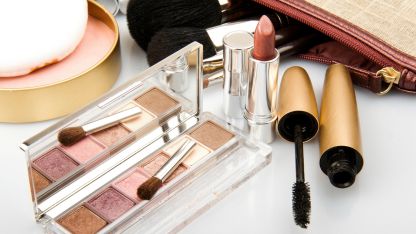 A variety of makeup products displayed neatly on a white surface, showcasing colors and textures in an organized manner.