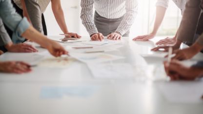 A group of business professionals collaborating around a conference table, engaged in discussion and teamwork.