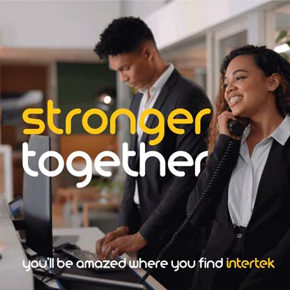 Two employees at a service desk speaking on the phone while smiling